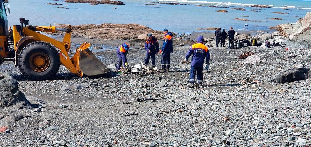 In this photo released by the Russian Emergency Ministry Press Service, emergency personnel work near the site where a helicopter carrying tourists crashed at Kurile Lake in the Kronotsky nature reserve on the Kamchatka Peninsula in Russia on Aug. 12, 2021. (Russian Emergency Ministry Press Service via AP)