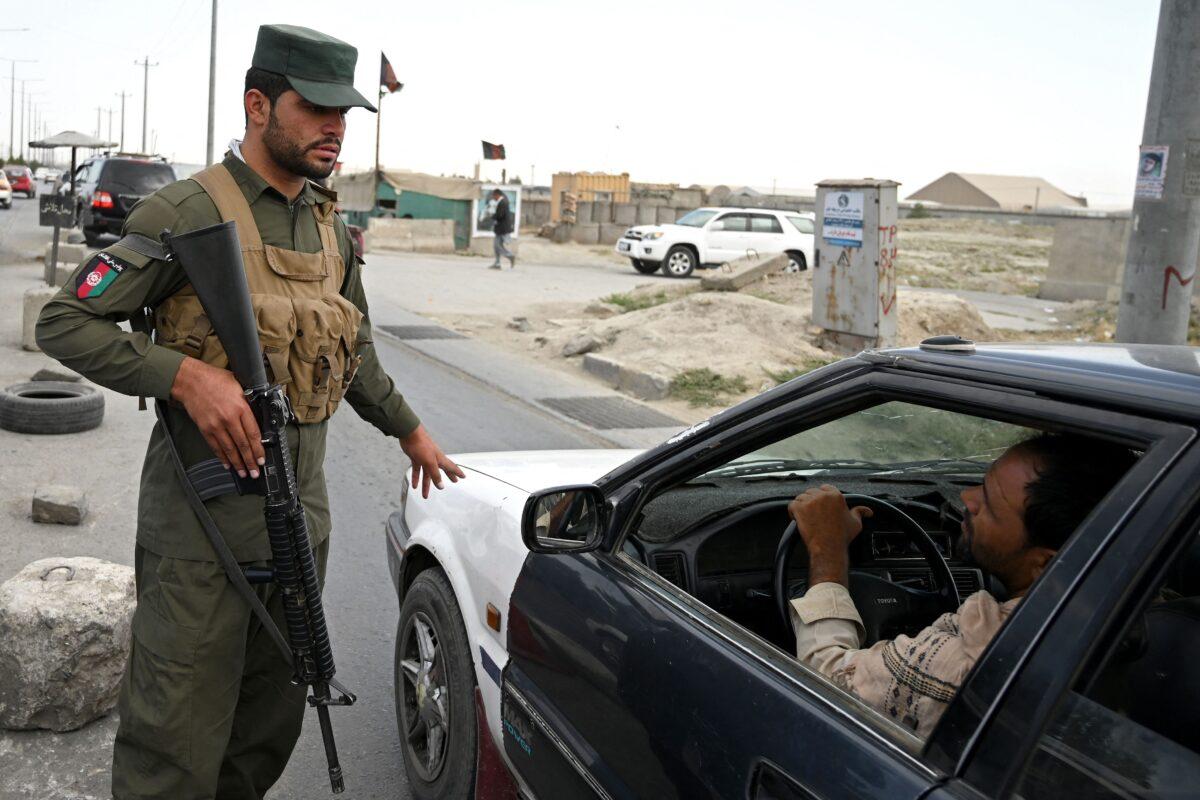 An Afghan policeman speaks to a commuter in a car at a checkpoint along the road in Kabul, Afghanistan on Aug. 14, 2021. (Wakil Kohsar/AFP via Getty Images)