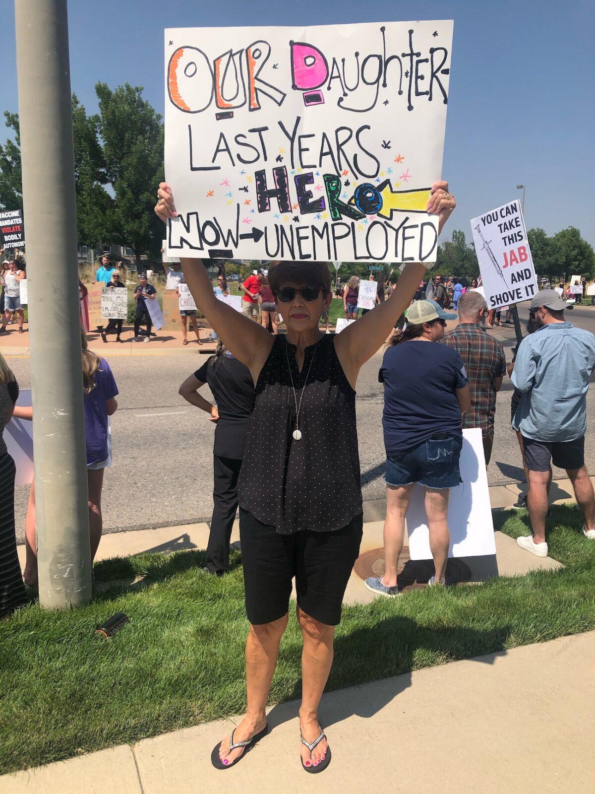 A protester holds a sign expressing the iron of yesterday's front-line heroes becoming today's unemployed healthcare workers because of their opposition to mandated COVID-19 vaccines in Loveland, Colo., on Aug. 13, 2021. (Allan Stein/The Epoch Times)