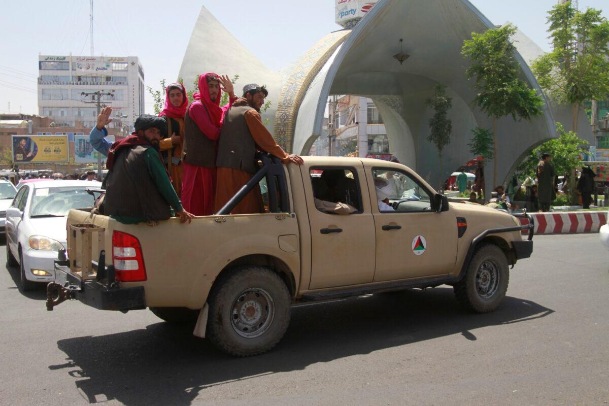 Taliban fighters sit on the back of a vehicle in the city of Herat, west of Kabul, Afghanistan on Aug. 14, 2021, after seizing the province from the Afghan government. (Hamed Sarfarazi/AP Photo)