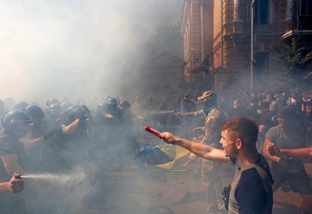 Demonstrators clash with police officers during a protest by activists of the National Corps political party in front of the presidential office building in Kyiv, Ukraine, on Aug. 14, 2021. (Serhii Nuzhnenko/Reuters)