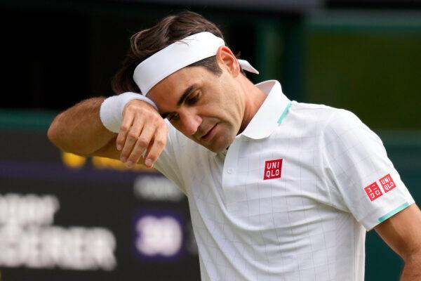 Switzerland's Roger Federer wipes his brow during the men's singles quarterfinals match against Poland's Hubert Hurkacz on day nine of the Wimbledon Tennis Championships in London, on July 7, 2021. (Kirsty Wigglesworth/AP Photo)