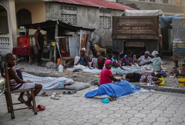 Locals begin to wake up after spending the night outside after the Aug. 14 7.2 magnitude earthquake in Les Cayes, Haiti, on Aug. 15, 2021. (Joseph Odelyn/AP Photo)
