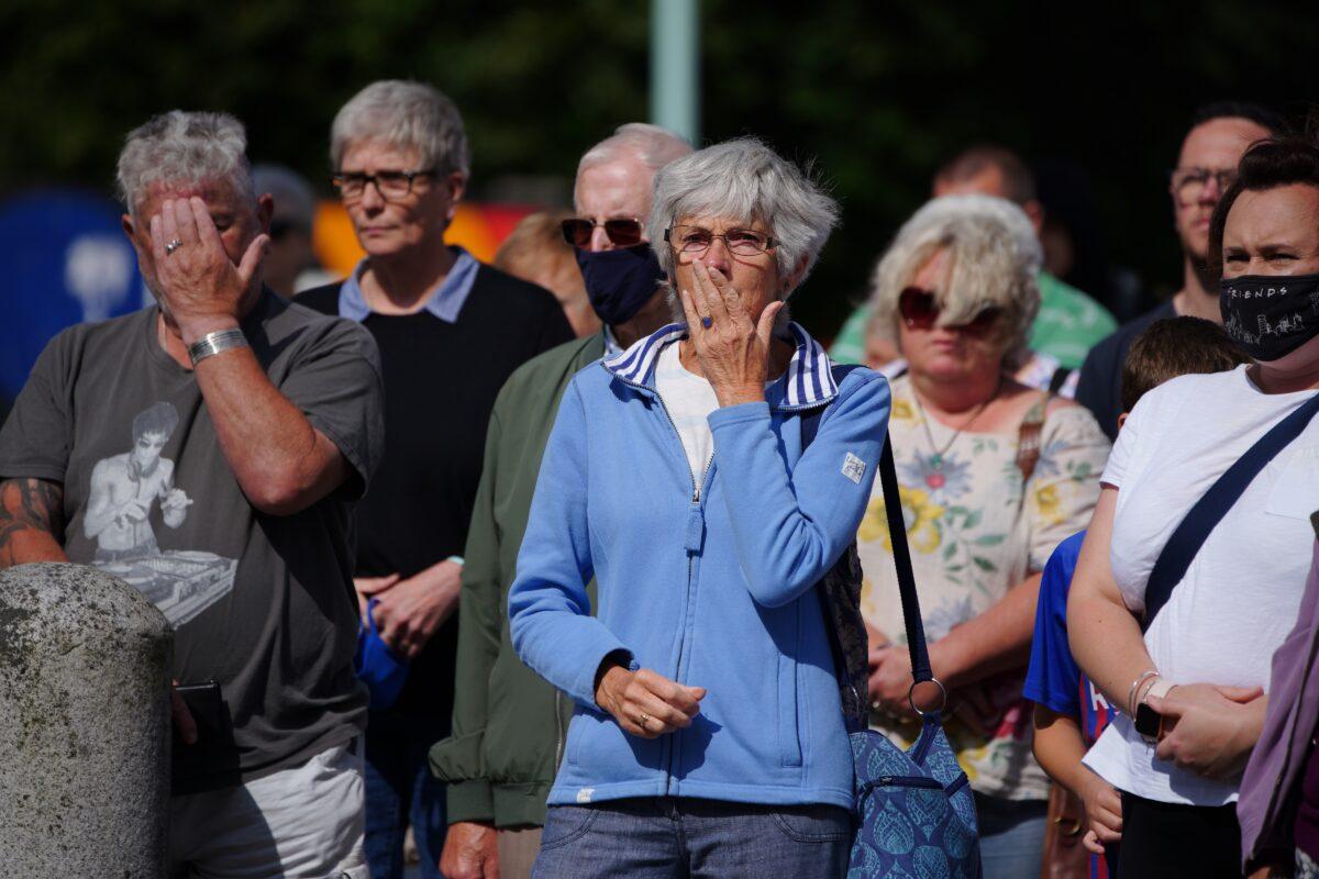 People take part in a minute's silence outside Plymouth Guildhall in memory of the five people that were killed by gunman Jake Davison in a firearms incident in Plymouth, United Kingdom, on Aug. 16, 2021. (Ben Birchall/PA)