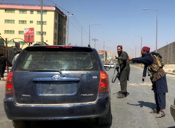 Members of Taliban forces gesture as they check a vehicle on a street in Kabul, Afghanistan, on Aug. 16, 2021. (Stringer/Reuters)