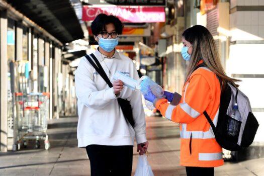 A volunteer distributes face masks in the Bankstown suburb of Sydney, Australia, on Aug. 11, 2021 (Saeed Khan/AFP via Getty Images)