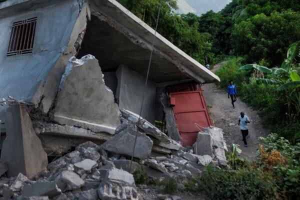 Residents walk past a collapsed building in Saint-Louis-du-Sud, Haiti, on Aug. 16, 2021. (Matias Delacroix/AP Photo)