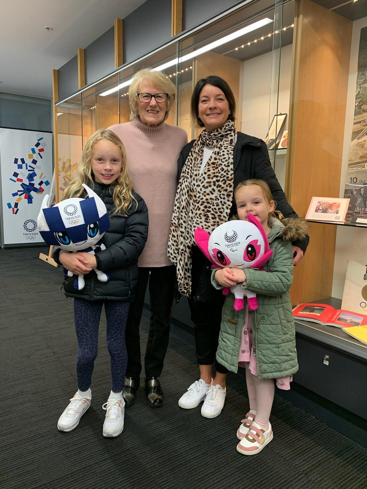 Jan Becker (L) with her daughter-in-law and granddaughters, visiting the "Memories of Tokyo 1964" exhibition at the Consulate-General of Japan in Melbourne, Australia, in July 2021. Items such as her scrapbook and commemorative stamps are currently on display. (Courtesy of Jan Becker)