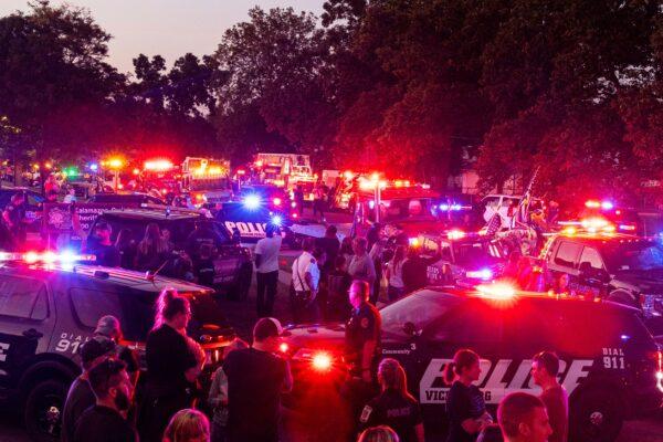 Emergency vehicles flash their lights at 9 p.m. along Lamont Avenue to honor Kalamazoo County Sheriff Deputy Ryan Proxmire outside the Sheriff's office in Kalamazoo, Mich., on Aug. 15, 2021. (Joel Bissell/Kalamazoo Gazette via AP)