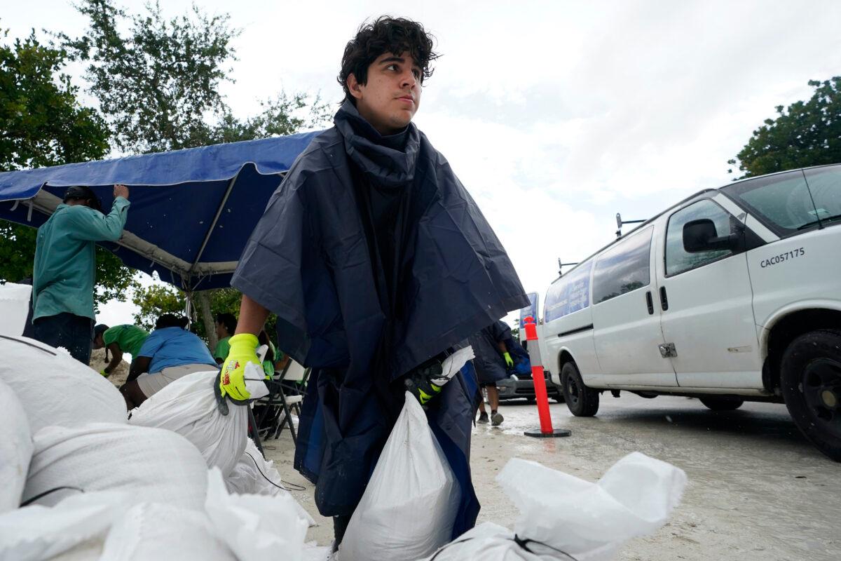 City worker Enrique Pulley prepares to load sandbags at a drive-thru sandbag distribution event for residents ahead of the arrival of rains associated with tropical depression Fred, at Grapeland Park in Miami, Fla., on Aug. 13, 2021. (Wilfredo Lee/AP Photo)