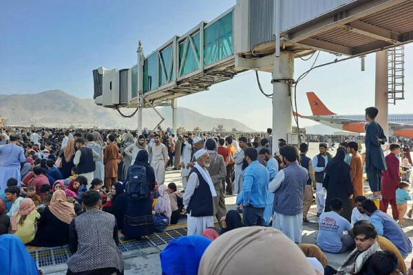 Afghans crowd at the tarmac of the airport in Kabul as they wait to flee Taliban control of Afghanistan after President Ashraf Ghani fled the country and conceded the insurgents had won the 20-year war on Aug. 16, 2021. (AFP via Getty Images)