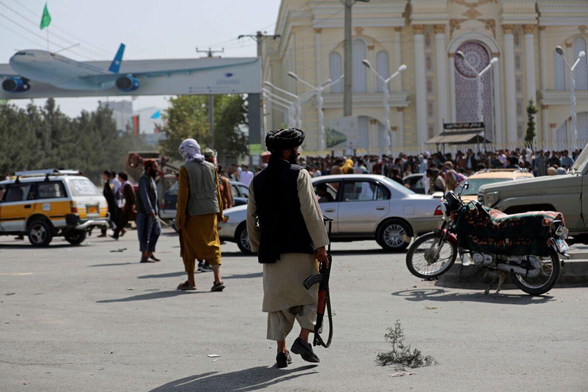 Taliban fighters stand guard in front of the Hamid Karzai International Airport, in Kabul, Afghanistan, on Aug. 16, 2021. (Rahmat Gul/AP Photo)