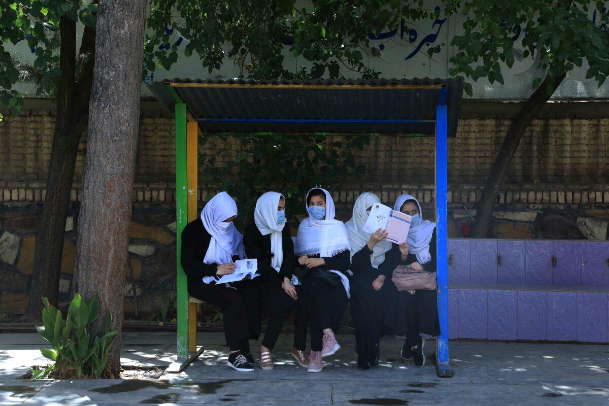 Schoolgirls sit at the schoolyard in Herat on Aug. 17, 2021, following the Taliban stunning takeover of the country. (Aref Karimi/AFP via Getty Images)
