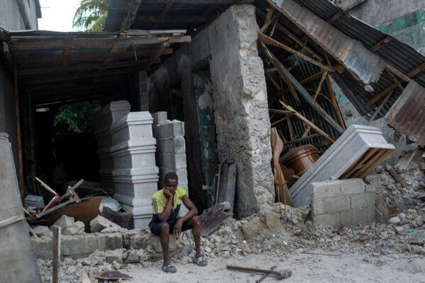 A man sits in front of a collapsed funeral home in Les Cayes, Haiti, on Aug. 16, 2021. (Matias Delacroix/AP Photo)