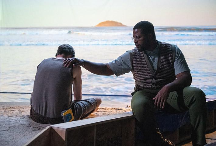 Will (Winston Duke) comforts Mike (David Rysdahl) after Mike experiences what walking in the ocean would be like, in “Nine Days.” (Michael Coles/Sony Pictures Classics)
