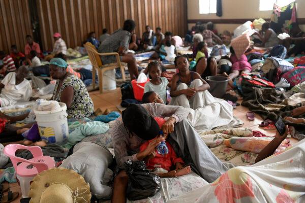 Earthquake-displaced people sit inside a church the morning after Tropical Storm Grace swept over Les Cayes, Haiti, on Aug. 17, 2021. (Matias Delacroix/AP Photo)
