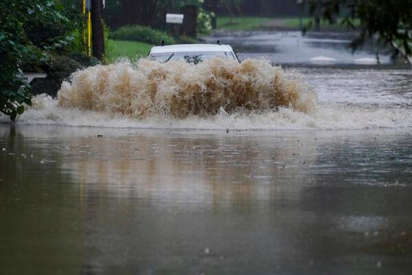 A car attempts to drive through flood waters near Peachtree Creek near Atlanta, as Tropical Storm Fred makes its way through north and central Georgia on Aug. 17, 2021. (Brynn Anderson/AP Photo)