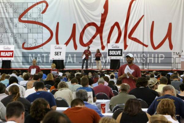 A tournament official, white hat, watches for participants to complete their puzzles during the Sudoku Tournament in Philadelphia, on Oct. 20, 2007. (Joseph Kaczmarek/AP Photo)