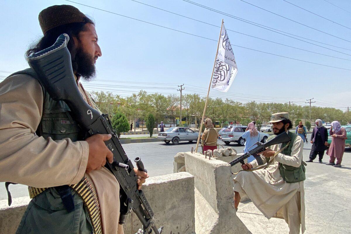 Taliban members stand guard at an entrance gate outside the Interior Ministry in Kabul, on Aug. 17, 2021. (Javed Tanveer/AFP via Getty Images)