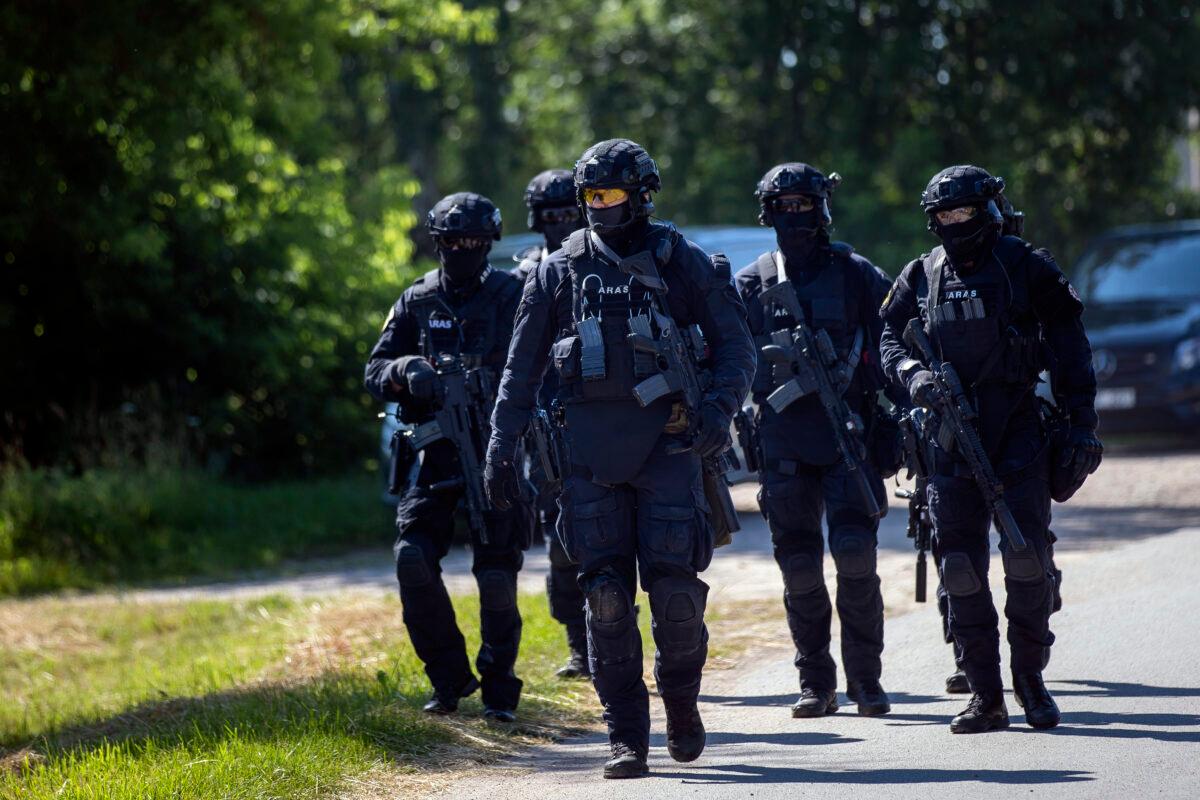 Members of the Lithuanian Police Anti-terrorist Operations Unit ARAS arrive at the refugee camp in the village of Vydeniai, Lithuania, on July 10, 2021. (Mindaugas Kulbis/AP Photo)