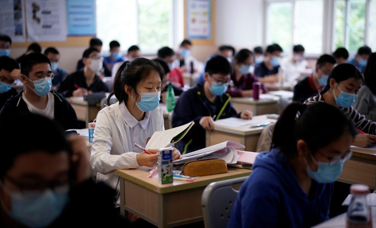 Students wearing face masks are seen inside a classroom during a regime-organized media tour at a high school as more students returned to campus following the coronavirus disease (COVID-19) outbreak, in Shanghai, China, May 7, 2020. (Aly Song/Reuters)