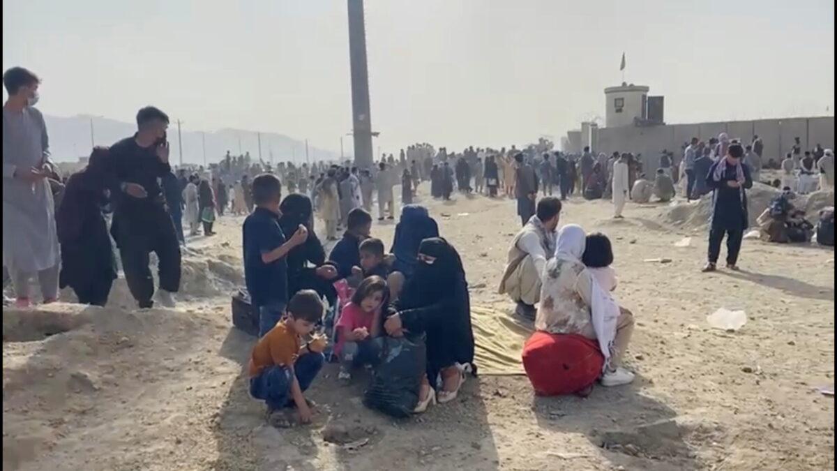 In this still image taken from video, people gathered outside the airport react to gunfire in Kabul, Afghanistan, on Aug. 18, 2021. (Asvaka News via Reuters)