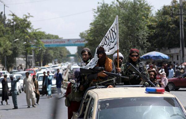 Taliban terrorists are seen on patrol while carrying the group's flag in Kabul, Afghanistan on Aug. 19, 2021. (Rahmat Gul/AP Photo)