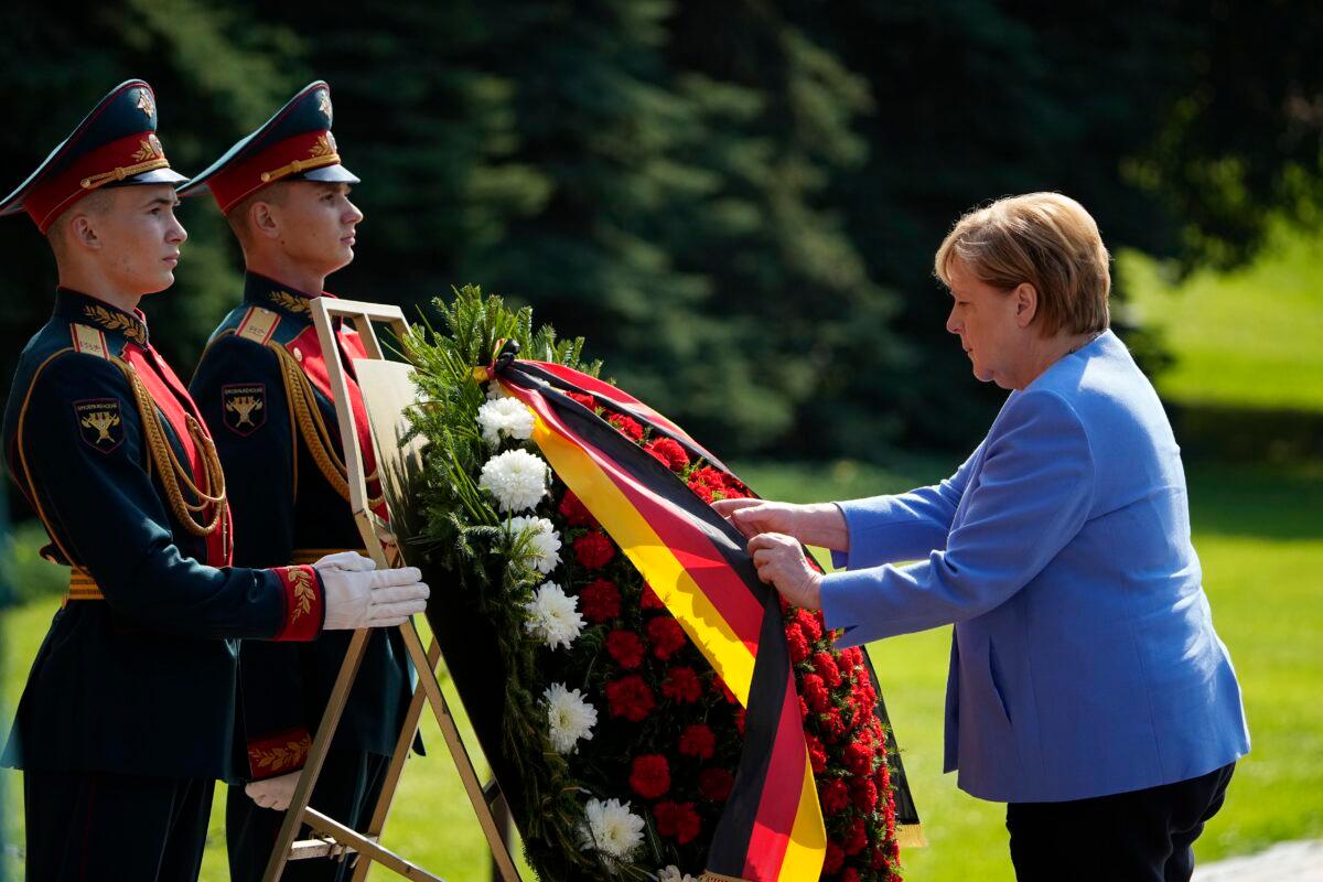 German Chancellor Angela Merkel attends a wreath laying ceremony at the Tomb of Unknown Soldier in Moscow, Russia, on Aug. 20, 2021. (Alexander Zemlianichenko/AP Photo)