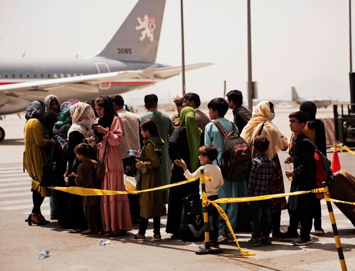 Civilians prepare to board a plane during an evacuation at Hamid Karzai International Airport, Kabul, Afghanistan, on Aug. 18, 2021. (Staff Sgt. Victor Mancilla/U.S. Marine Corps via AP)