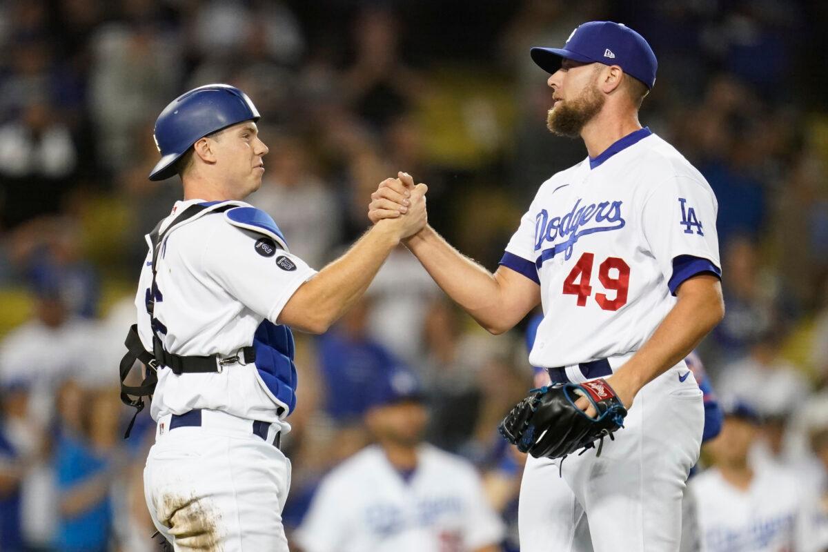 Los Angeles Dodgers catcher Will Smith, left, and relief pitcher Blake Treinen (49) celebrate after a 4-1 win over the New York Mets in their baseball game in Los Angeles on Aug. 19, 2021. (AP Photo/Ashley Landis)
