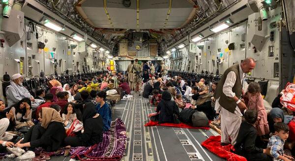 Afghan people sit inside a U.S. military aircraft to leave Afghanistan, after the Taliban's takeover of the country, at the military airport in Kabul on Aug. 19, 2021. (Shakib Rahmani/AFP via Getty Images)