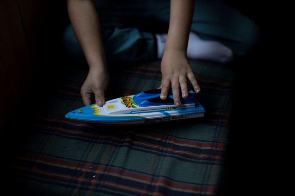 Diego Guerrero, 7, plays with his toy boat, in the kitchen of his home, in the village of Sotomo, outside the town of Cochamo, Los Lagos region, Chile, on Aug. 6, 2021. (Pablo Sanhueza/Reuters)