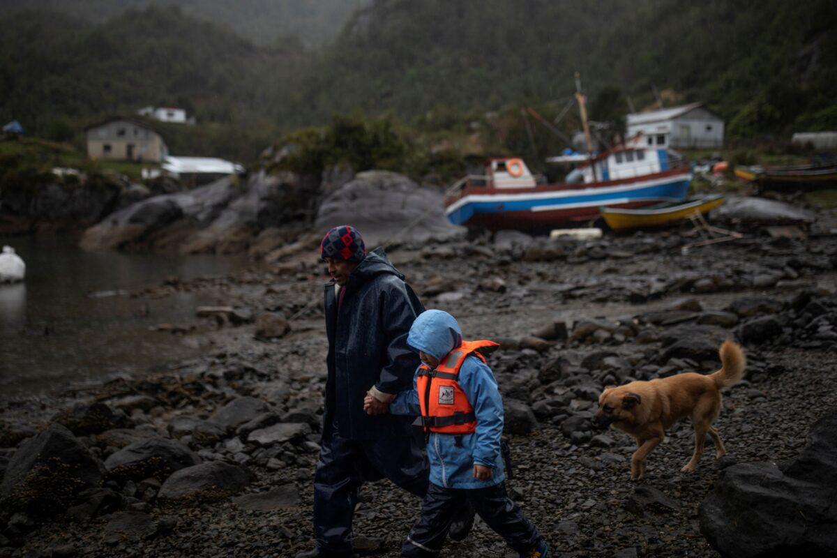 Carlos Guerrero, 40, with his son Diego, 7, start their journey to John F Kennedy School in the village of Sotomo, outside the town of Cochamo, Los Lagos region, Chile, on Aug. 6, 2021. (Pablo Sanhueza/Reuters)