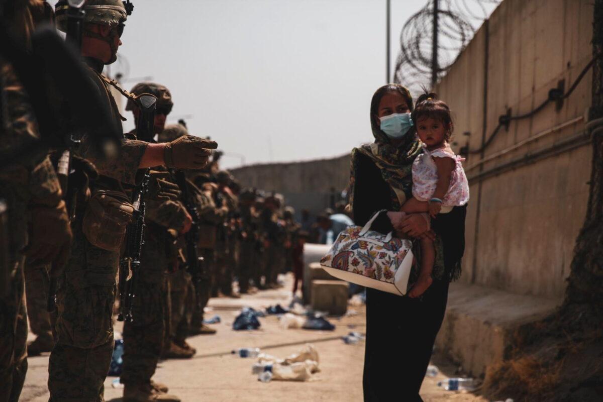 Marines with the 24th Expeditionary Unit (MEU) guide an evacuee during an evacuation at Hamid Karzai International Airport, Kabul, Afghanistan, on Aug. 18, 2021. (U.S. NAVY/Central Command Public Affairs/Sgt. Isaiah Compbell via Reuters)
