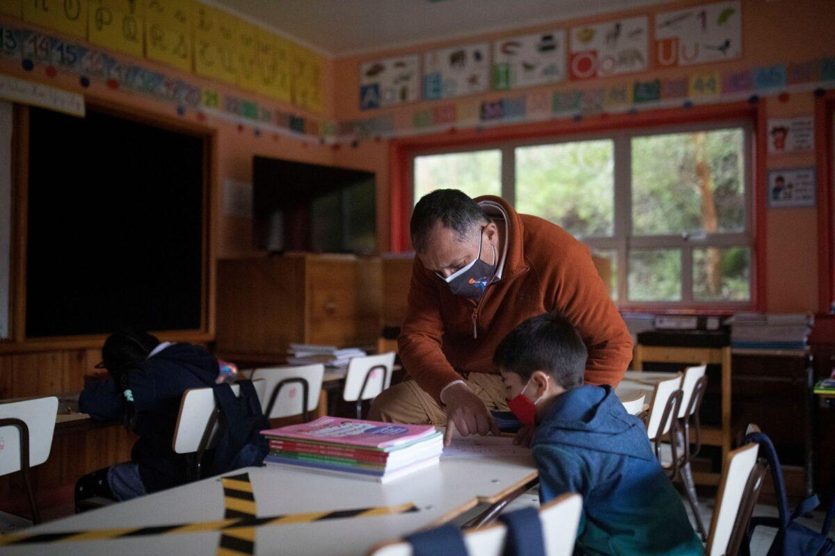 Teacher Javier de La Barra Casanova, 58, works with Diego Guerrero, 7, during one of his classes at the John F Kennedy School in the village of Sotomo, outside the town of Cochamo, Los Lagos region, Chile, on Aug. 6, 2021. (Pablo Sanhueza/Reuters)