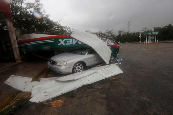 Vehicles lay under a metallic structure brought down by the winds of Hurricane Grace in Playa del Carmen, Quintana Roo state, Mexico, on Aug. 19, 2021. (Marco Ugarte/AP Photo)