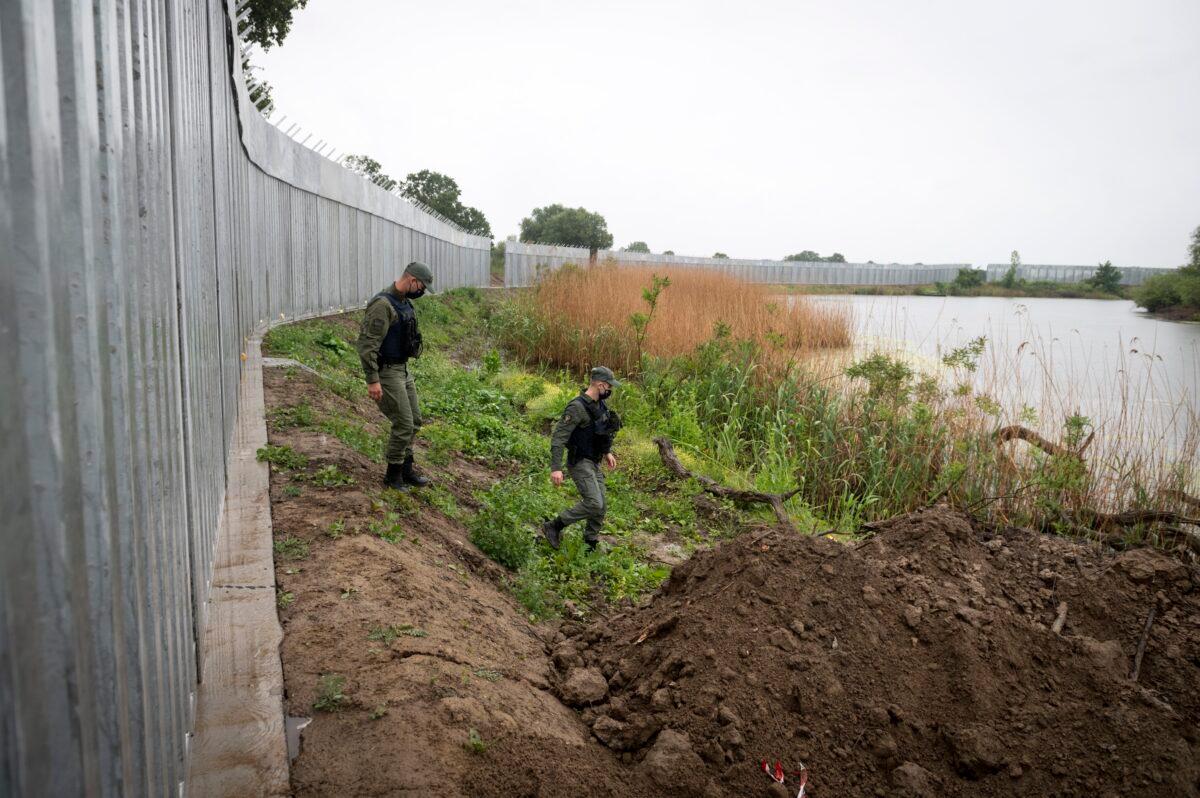 Policemen patrol alongside a steel wall at Evros River, near the village of Poros, at the Greek-Turkish border, on May 21, 2021. (Giannis Papanikos /AP Photo)