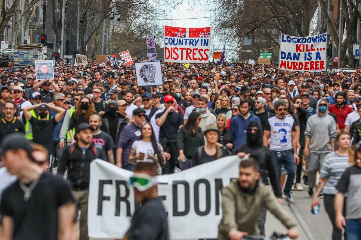 Protesters are seen marching holding banners in Melbourne, Australia, on Aug, 21, 2021. (Getty Images)