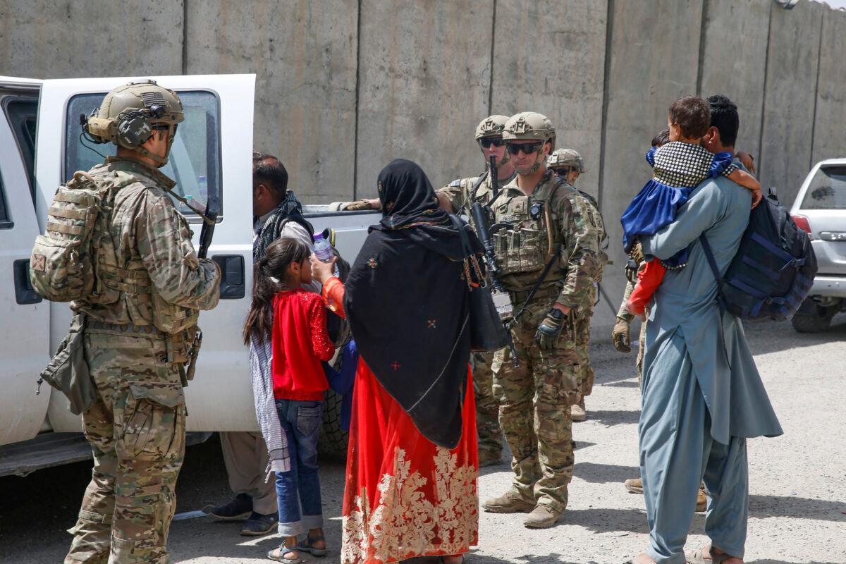 Soldiers assigned to 3rd Brigade, 10th Mountain Division escort evacuees to the terminal for check-in during an evacuation at Hamid Karzai International Airport in Kabul, Afghanistan, on Aug. 20, 2021. (Lance Cpl. Nicholas Guevara/U.S. Marine Corps via AP)
