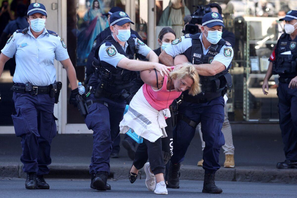 Police officers detain an alleged protester in Sydney, Australia, on Aug. 21, 2021. (David Gray/AFP via Getty Images)