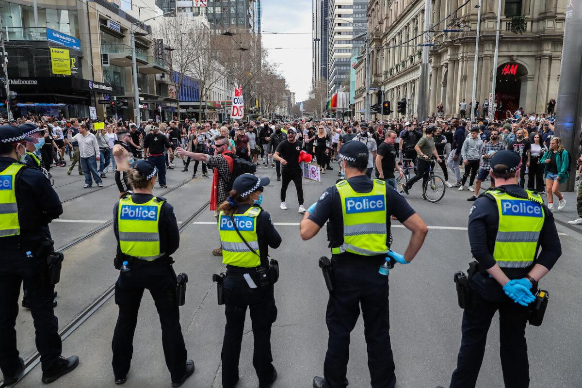 Protesters shout and gesture towards police officers in Melbourne, Australia, on Aug. 21, 2021. (Getty Images)
