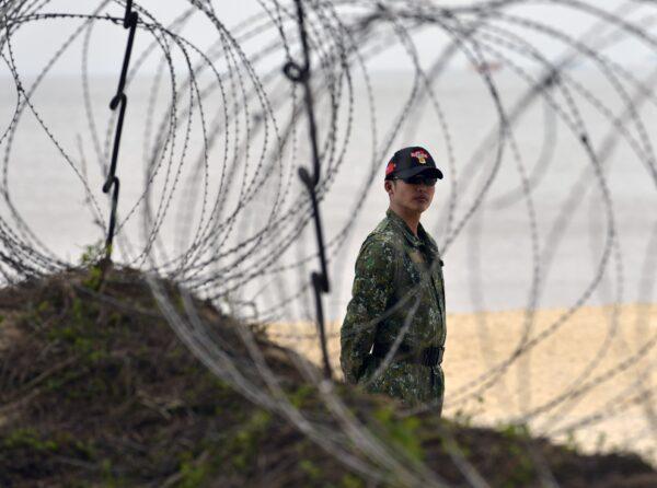 A Taiwanese marine officer stands behind barbed wire at Liaolo Bay, on the front line island of Kinmen, Taiwan, on Jan. 26, 2016. (Sam Yeh/AFP via Getty Images)