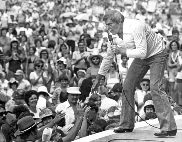 Singer Tom T. Hall leans to the edge of the stage at the Jamboree in the Hills to meet the people near St. Clairsville, Ohio, on July 16, 1977. (File/AP Photo)