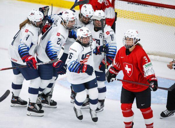 United States' Kendall Coyne Schofield (26) celebrates her goal as Switzerland's Sarah Forster skates away during the second period of an IIHF women's hockey championships game in Calgary, Alberta, on Aug. 20, 2021. (Jeff McIntosh/The Canadian Press via AP)