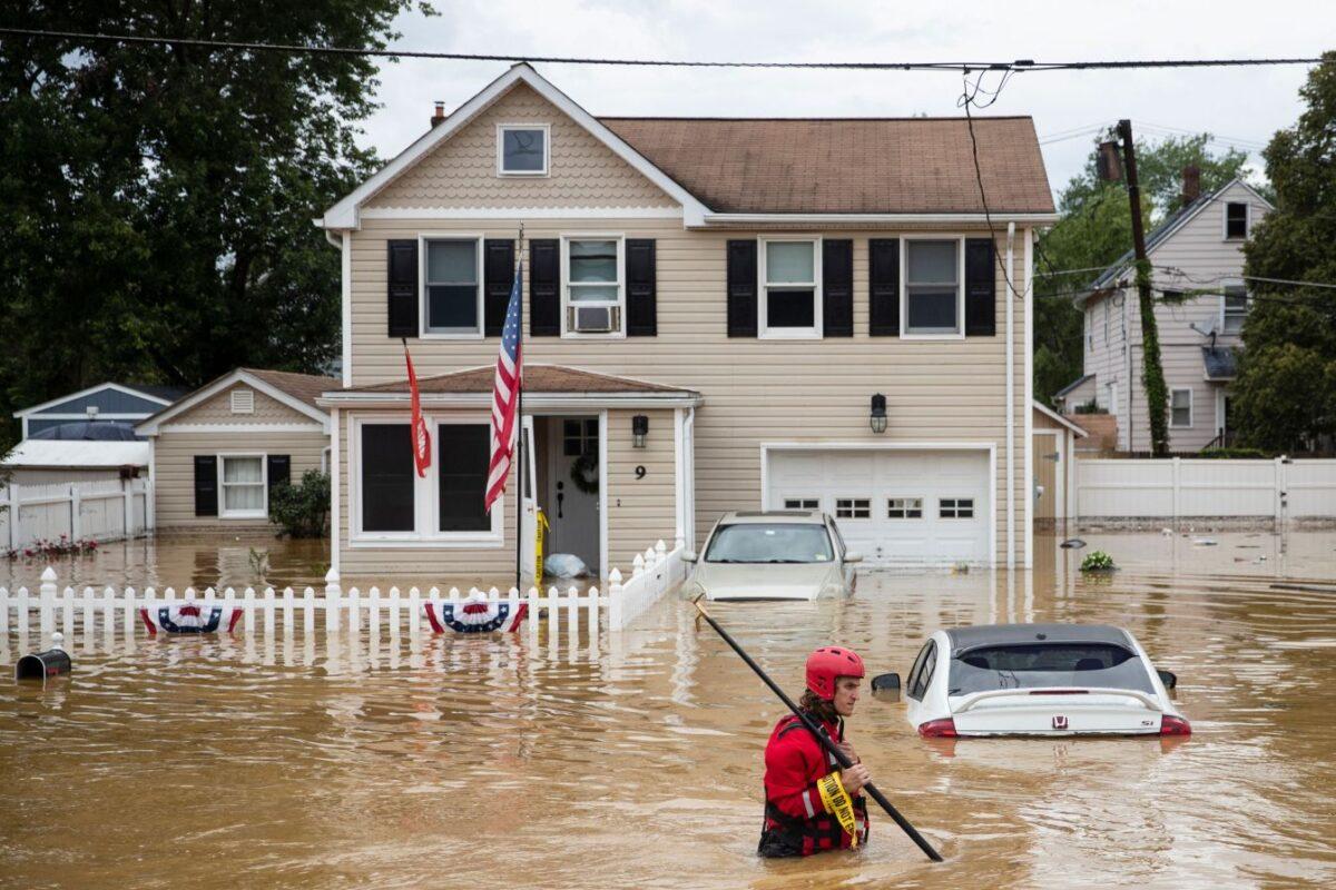 A New Market Volunteer Fire Company rescue crew member wades through high waters following a flash flood, as Tropical Storm Henri makes landfall, in Helmetta, N.J., on Aug. 22, 2021. (Tom Brenner/AFP via Getty Images)