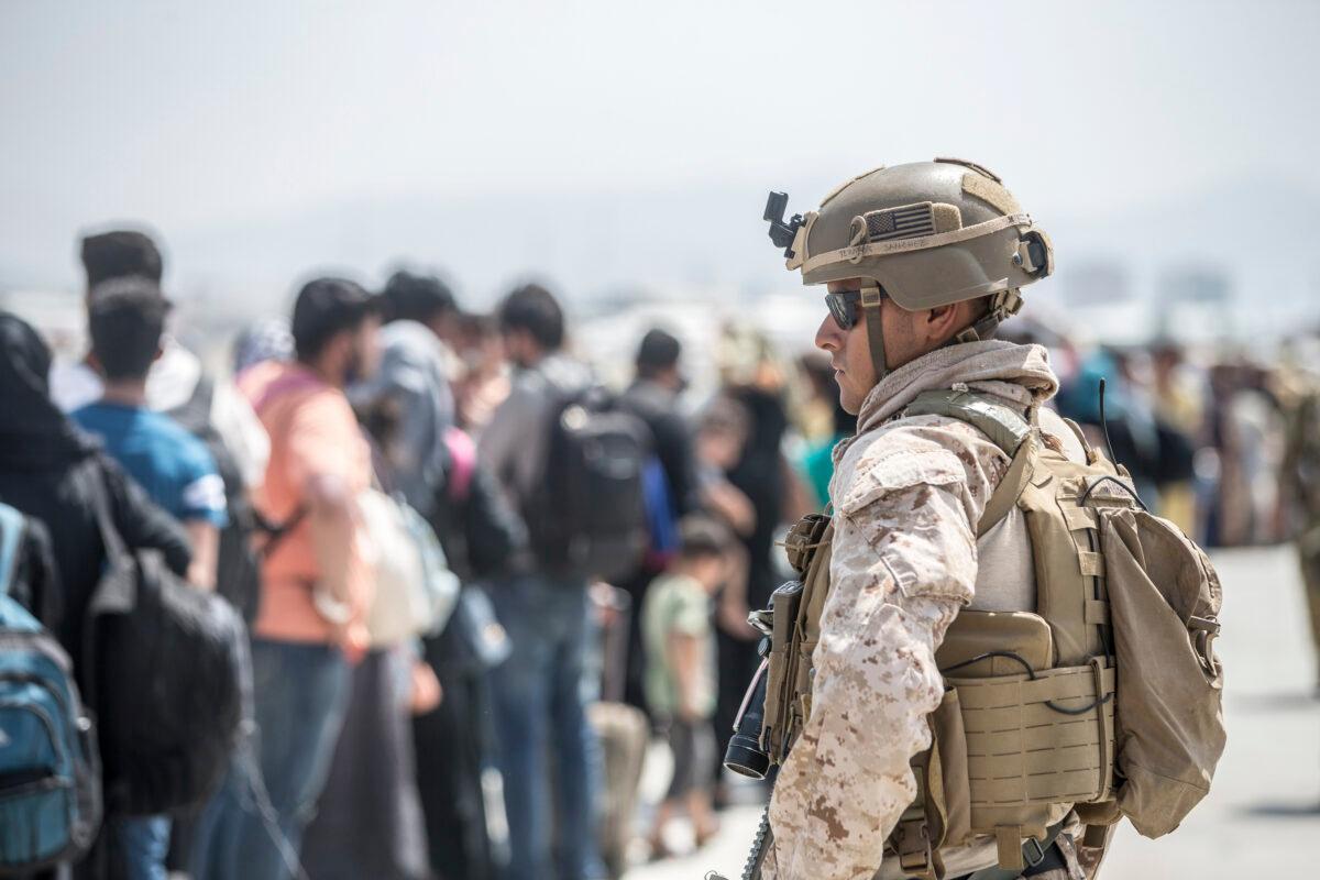 A Marine with Special Purpose Marine Air-Ground Task Force-Crisis Response-Central Command provides assistance during an evacuation at Hamid Karzai International Airport in Kabul, Afghanistan, on Aug. 22, 2021. (Sgt. Samuel Ruiz/U.S. Marine Corps via AP)