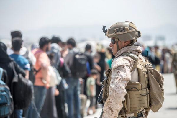 A Marine with Special Purpose Marine Air-Ground Task Force-Crisis Response-Central Command provides assistance during an evacuation at Hamid Karzai International Airport in Kabul, Afghanistan, on Aug. 22, 2021. (Sgt. Samuel Ruiz/U.S. Marine Corps via AP)