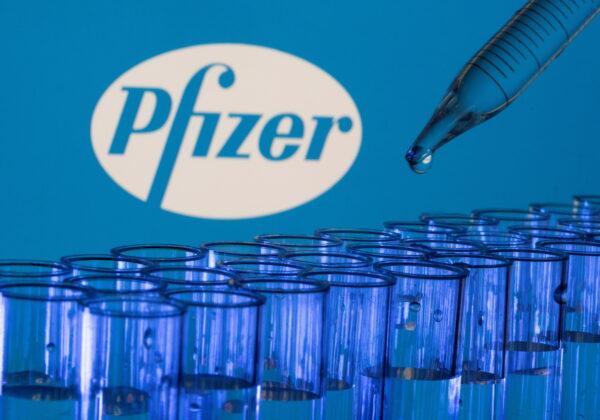 Test tubes are seen in front of a displayed Pfizer logo in this illustration photo taken on May 21, 2021. (Dado Ruvic/Illustration/Reuters)