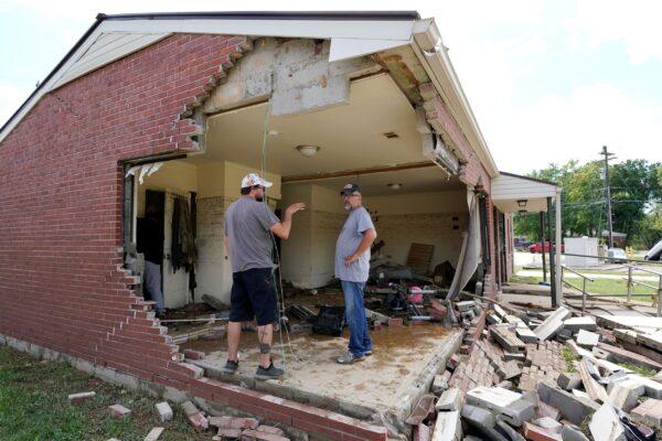 Brian Mitchell (R) looks through the damaged home of his mother-in-law along with family friend Chris Hoover in Waverly, Tenn., on Aug. 22, 2021. (Mark Humphrey/AP Photo)