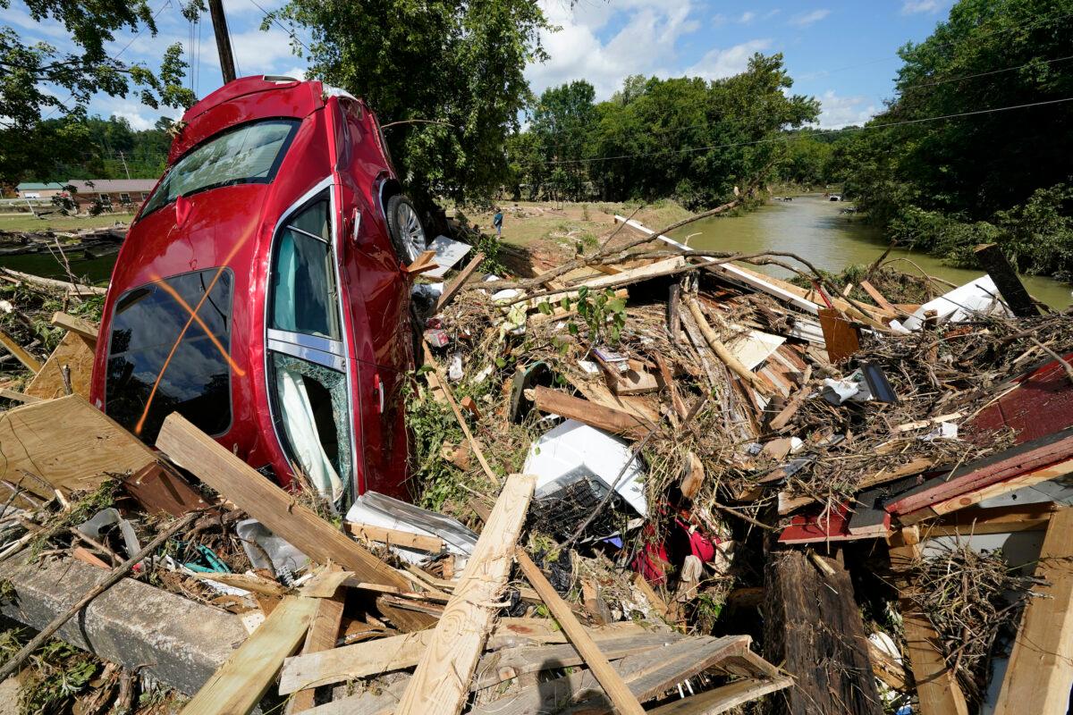 A car is among debris that washed up against a bridge over a stream in Waverly, Tenn., on Aug. 22, 2021. (Mark Humphrey/AP Photo)